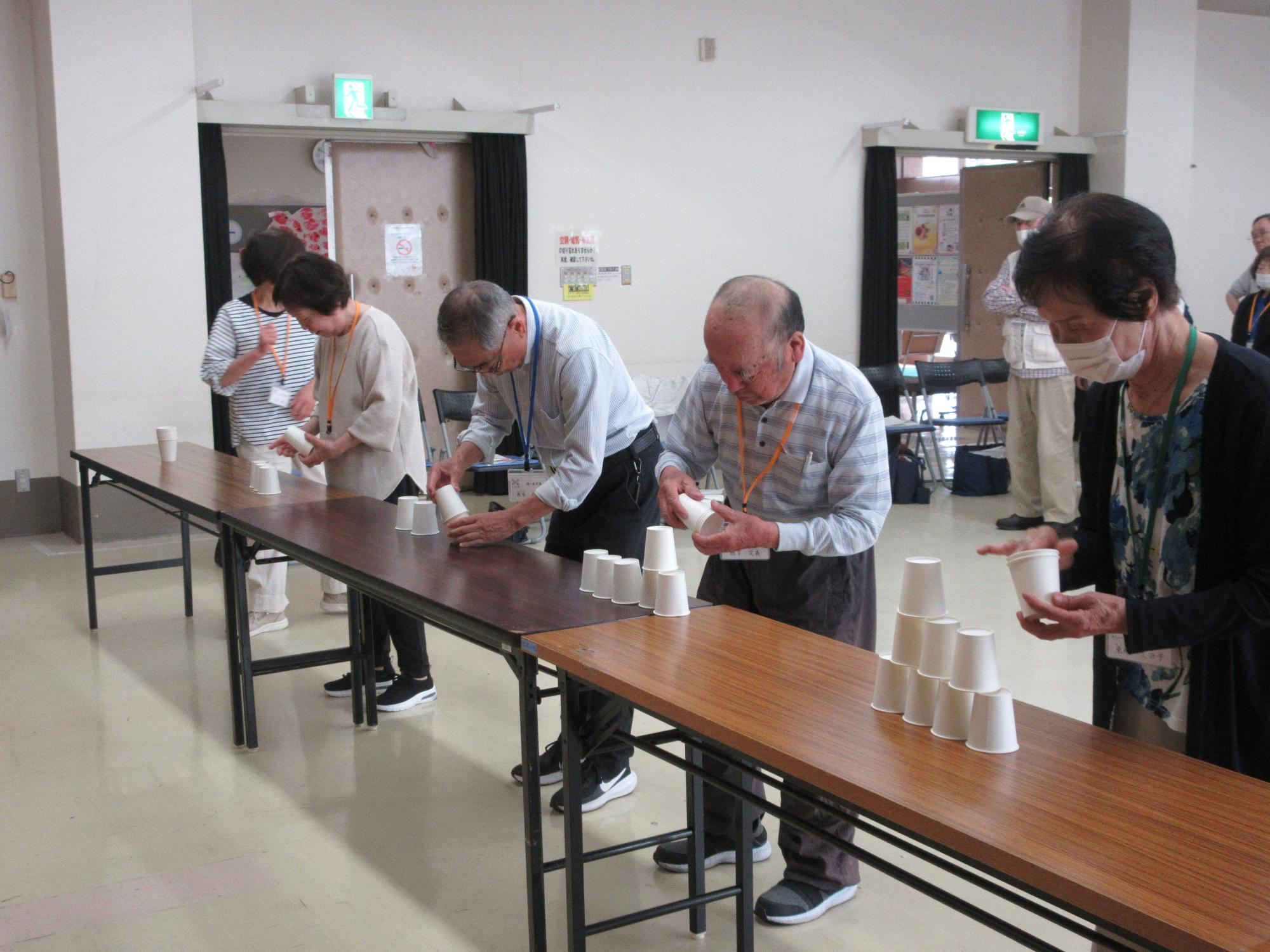 紙コップでタワーを作って、チームでリレーする様子