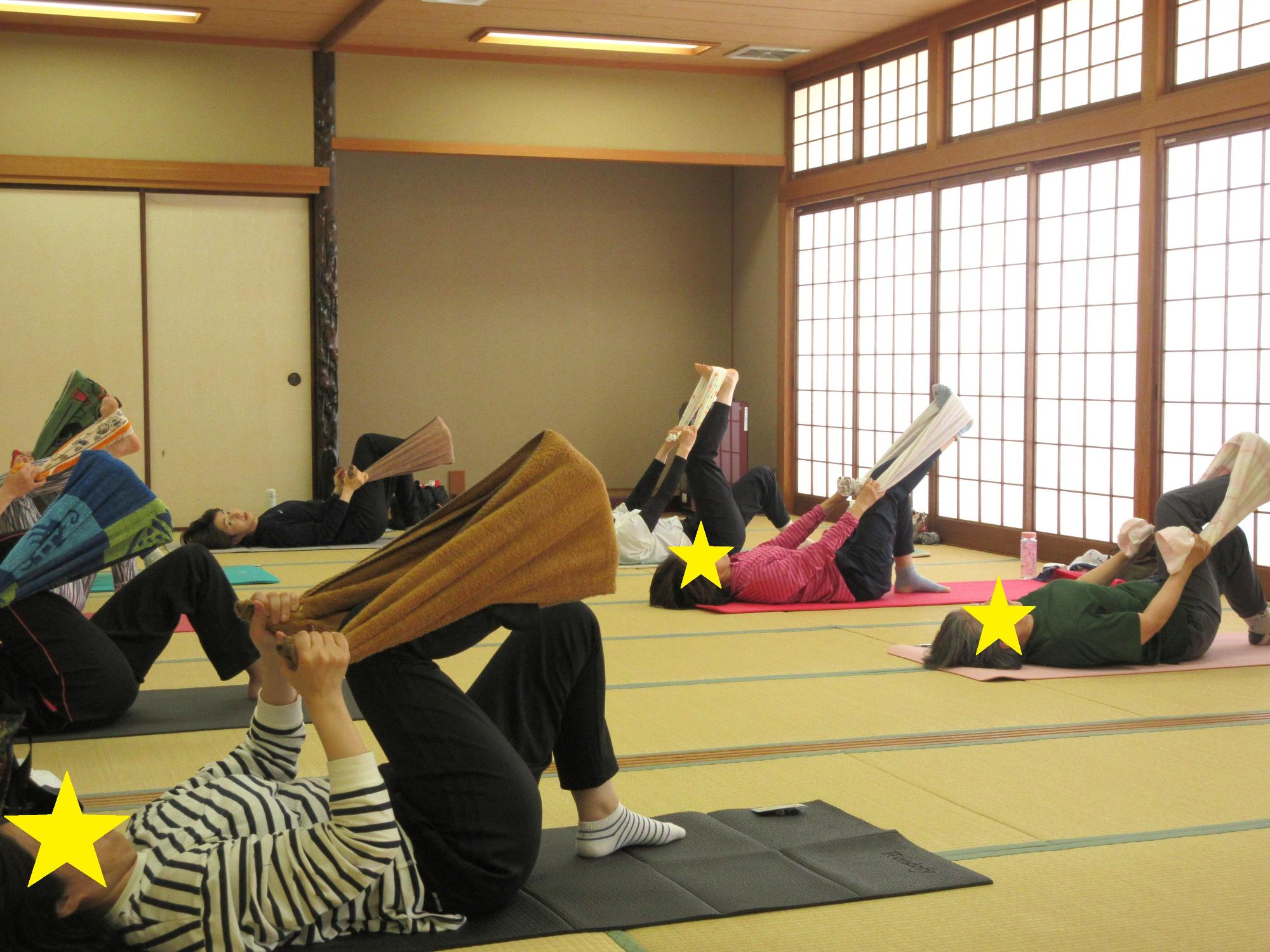 床に仰向けで寝ころび、両手でもったタオルを足で蹴るようす