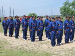 制服を着た消防団員たちが四列に並び礼式訓練を行っている写真