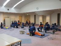 救急講習で男性団員が心肺蘇生を実演している写真