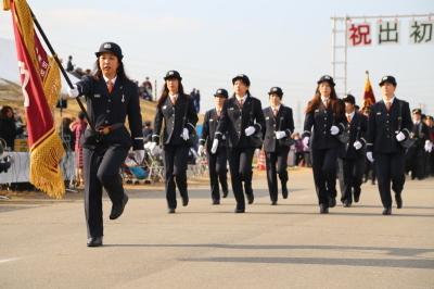 消防出初式で制服姿で行進をする団員達の写真