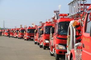 出初め式で長い車列を作った消防車両が行進している写真